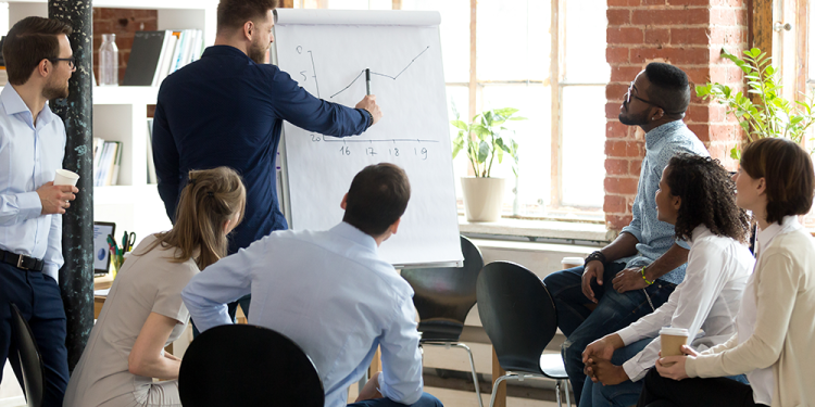 Business professionals reviewing information together during a sales conversation, representing a discussion where a buyer compares competitors before making a decision.