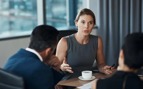 Business professional listening to a skeptical client during a meeting, capturing the moment when a prospect questions the seller’s credibility.