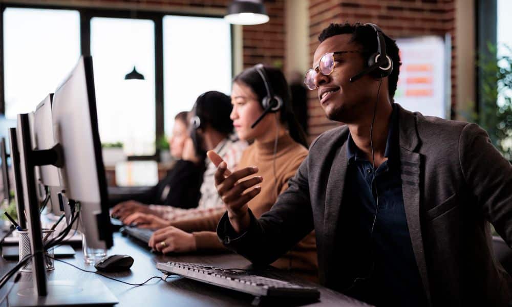 Sales professional speaking on the phone in a modern office while reviewing notes, representing consistent daily prospecting habits that strengthen the sales pipeline.