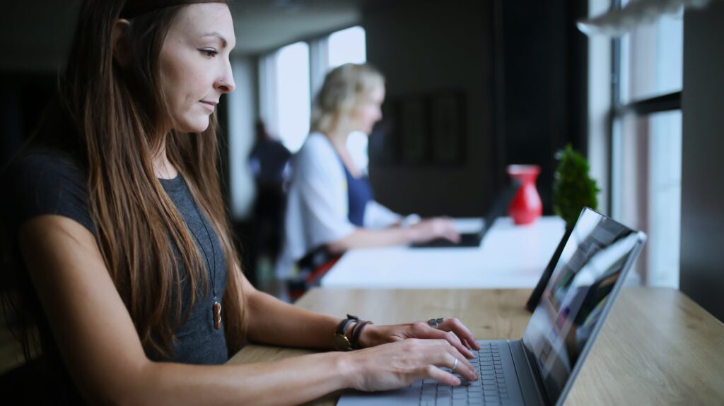 An employer working on a laptop in a modern office environment, focusing on maintaining their core responsibilities while AccountMakers’s EOR services handle HR and administrative tasks.