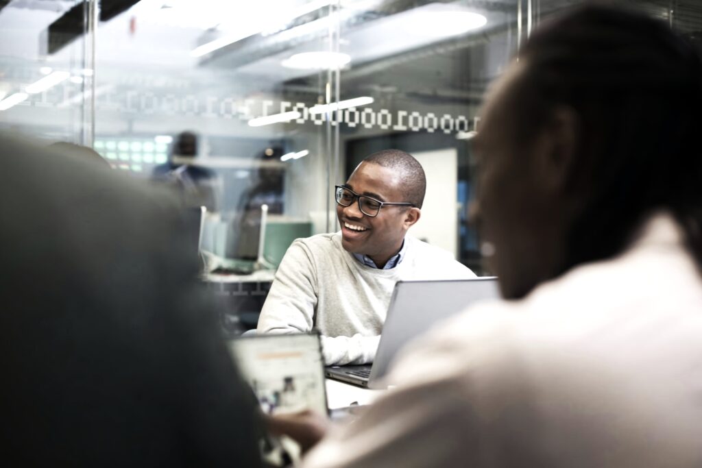 A group of executives engaged in a positive discussion in a collaborative environment, focusing on team dynamics while administrative and compliance tasks are managed by AccountMakers's Employer of Record (EOR) services.