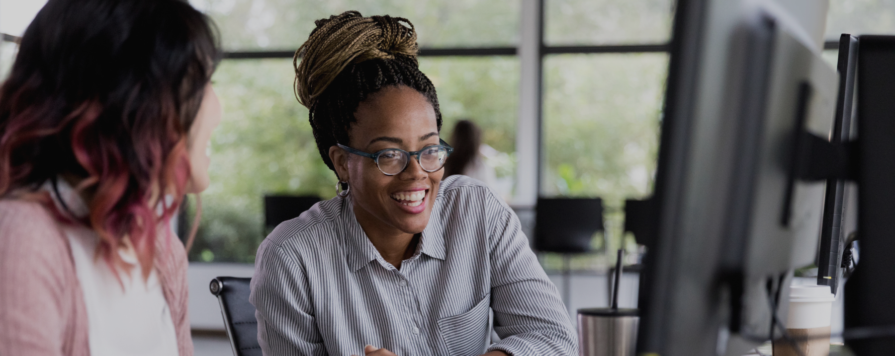 Los Angeles Customer Service Staffing - image of Los Angeles customer service representative sitting at desk laughing with coworker