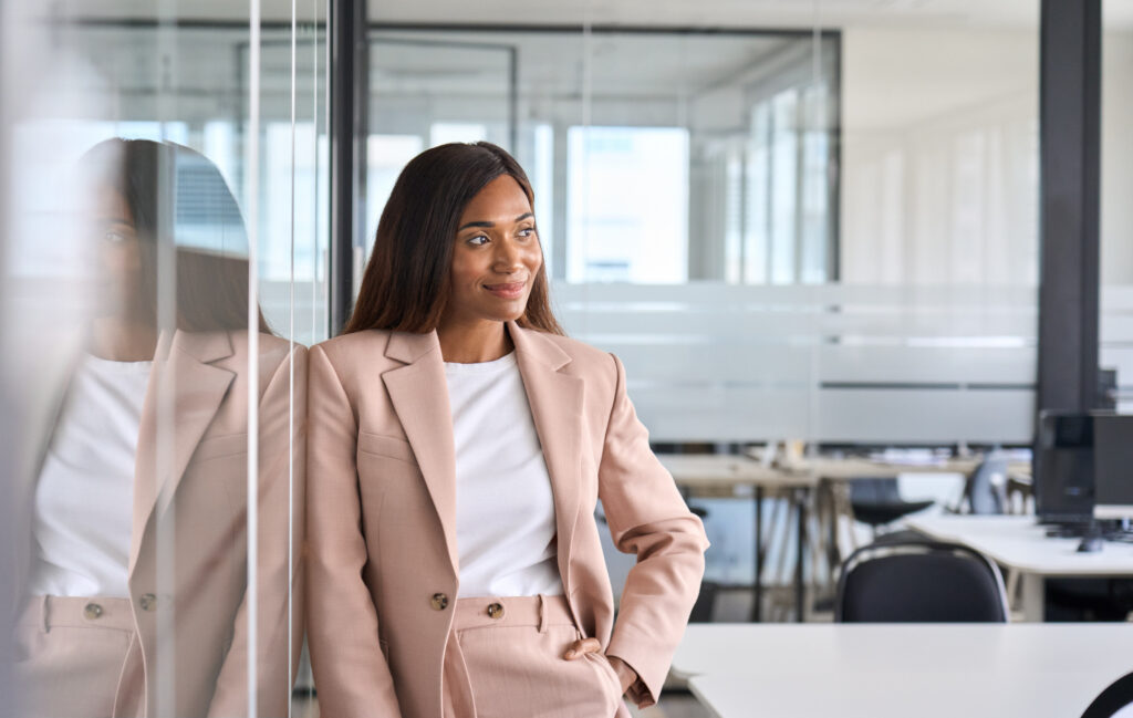 Los Angeles Sales Manager Staffing Recruiter is seen smiling standing in front of a conference room in a suit.
