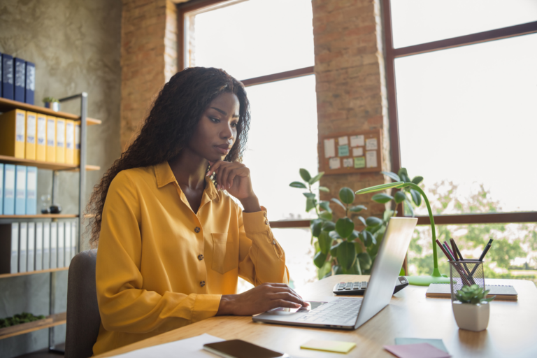Professional reviewing a role and implementation hiring needs on a laptop