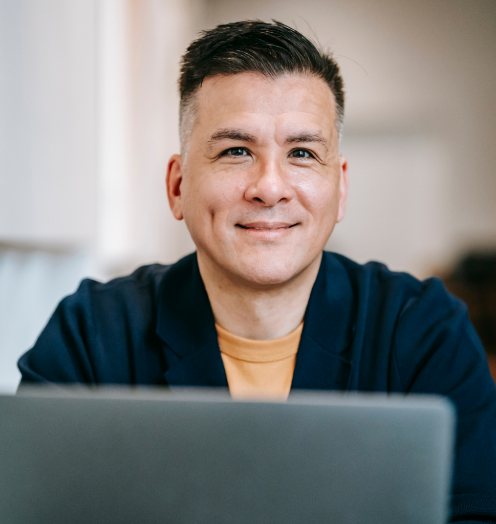 Sales professional working on a laptop and managing client relationships in a modern office