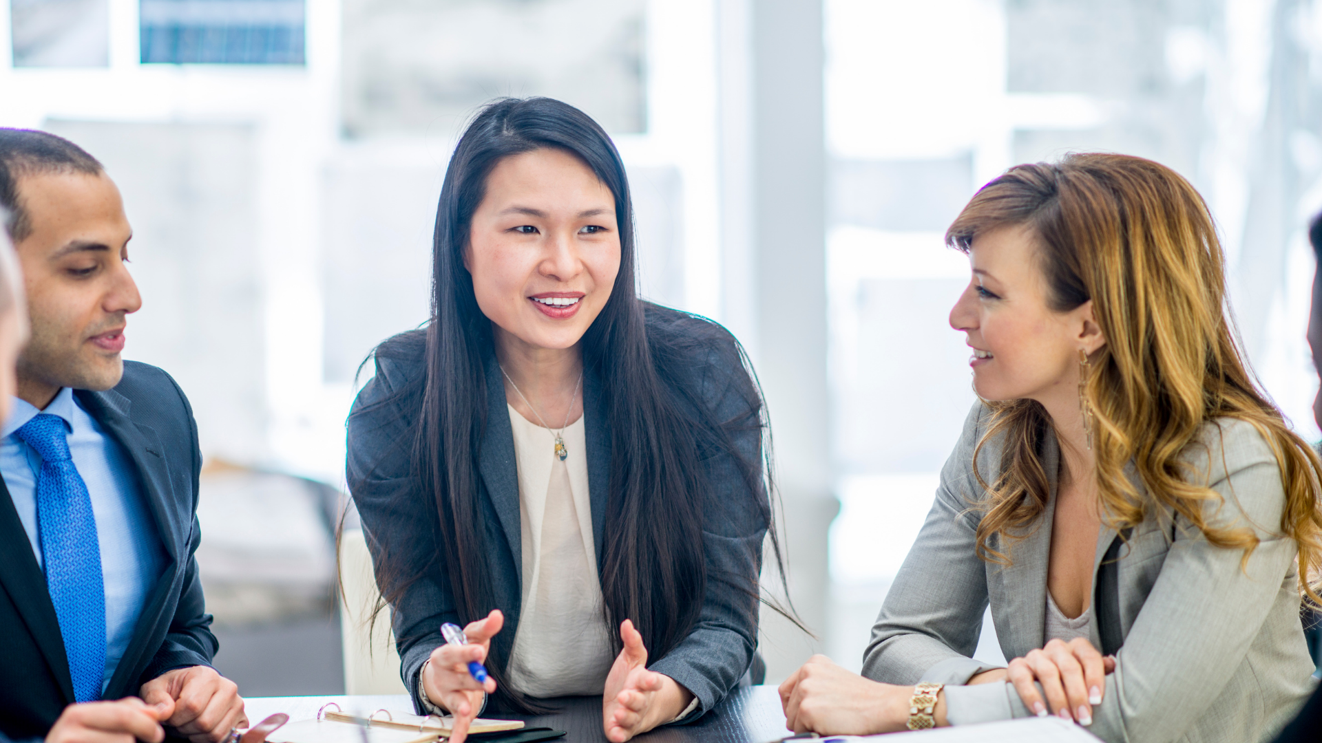 Sales professionals collaborating and discussing strategy during a team meeting