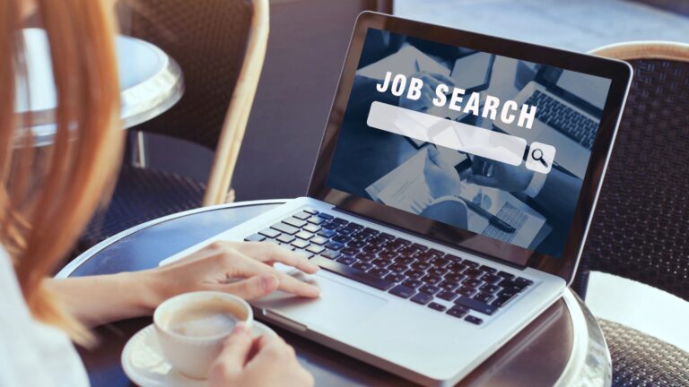 Person at coffee shop on laptop searching for jobs